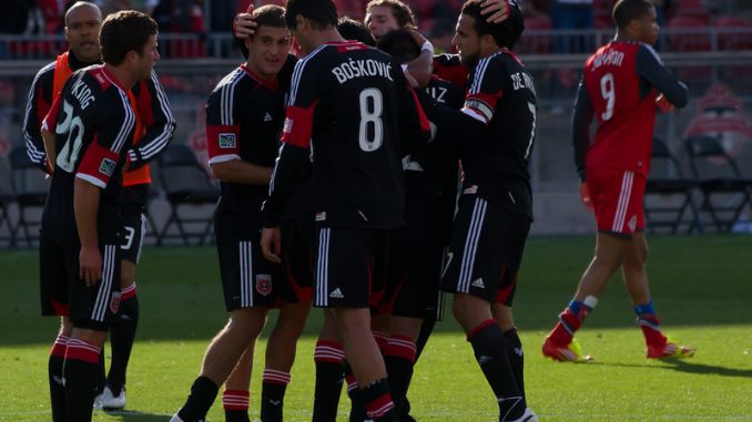 DC United Captain Dwayne De Rosario celebrates a 2-0 win with his teammates against his old team at BMO Field. In the background frustrated Toronto FC forward Ryan Johnson walks off the pitch (JP Dhanoa)